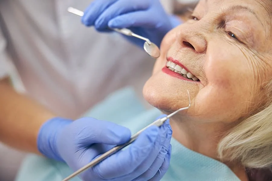 Lady getting her teeth fixed by a dentist